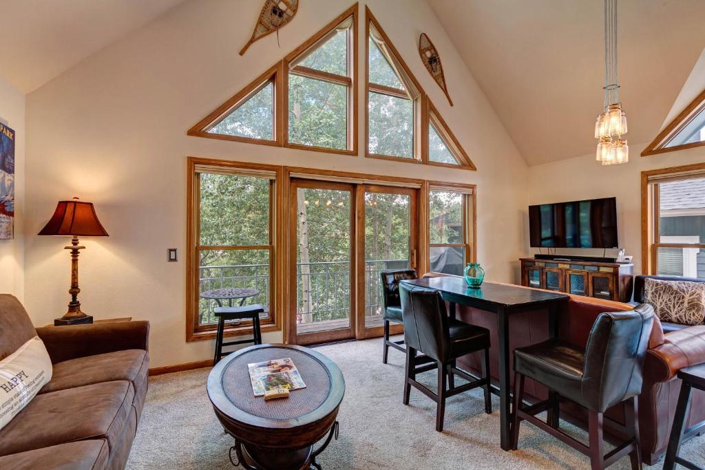 a living room with a vaulted ceiling with a large window at Silver Jacks Condo in Breckenridge