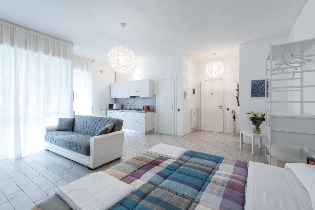 a white living room with a couch and a chair at Casa Giovanni in Bergamo
