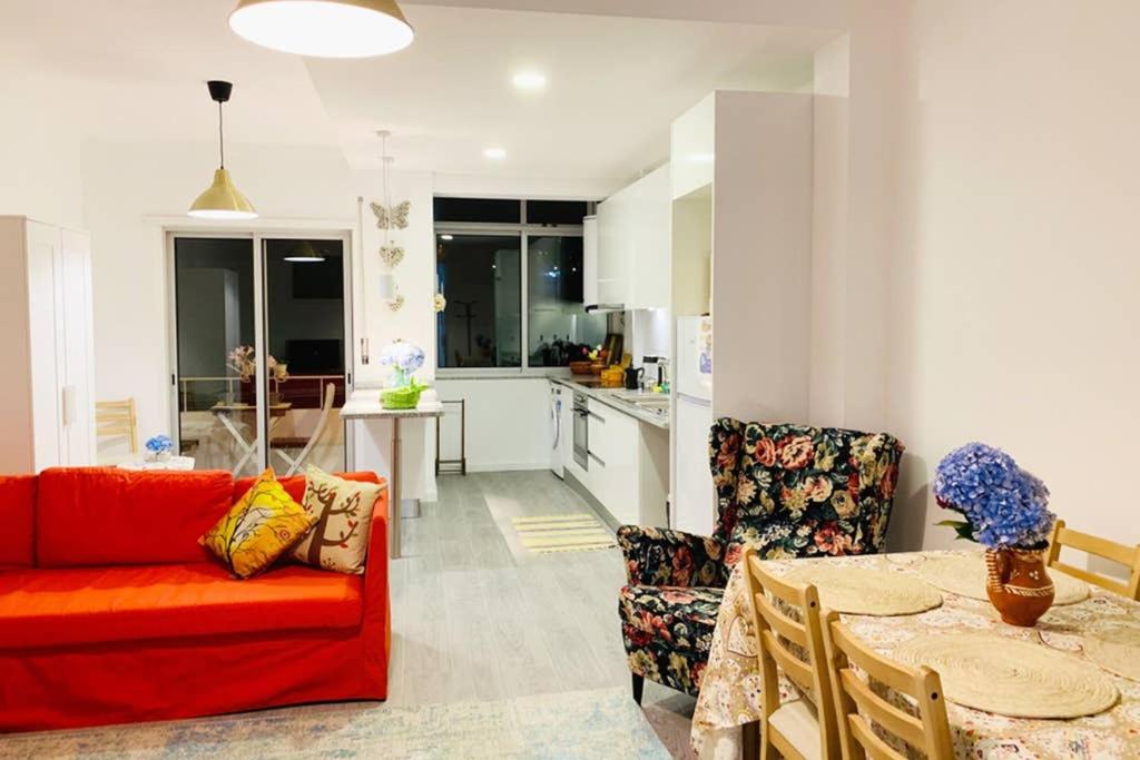 a living room with a red couch and a table at Braga Forum House in Braga