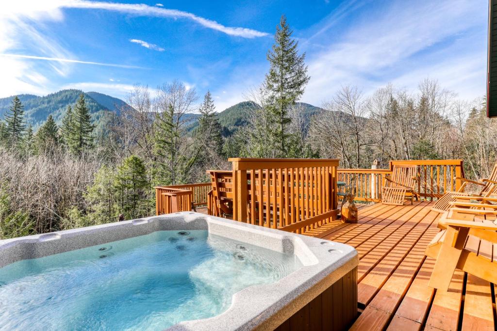 una bañera de hidromasaje en una terraza con montañas al fondo en Welches Mt. Retreat en Welches