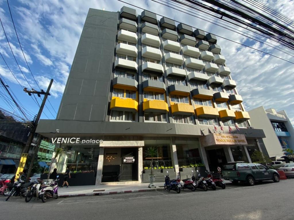 a large building with motorcycles parked in front of it at Venice Palace Hotel in Sungai Kolok