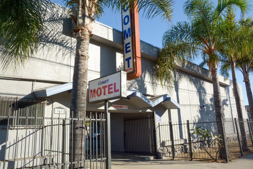 a motel sign in front of a building with palm trees at Comet Motel in Los Angeles