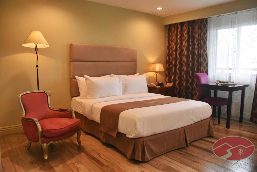 Habitación de hotel con cama y silla en Skyland Garden Hotel and Resort en Baguio