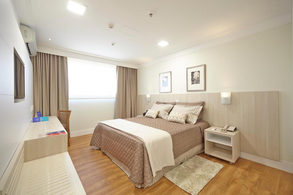 ein Schlafzimmer mit einem großen Bett und einem Fenster in der Unterkunft Porto Feliz Executive Hotel in Pôrto Feliz
