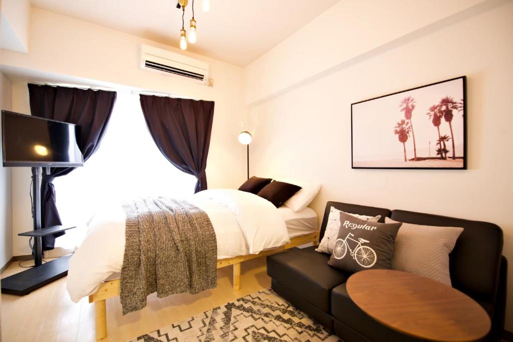 1 dormitorio con 1 cama y 1 sofá en Grandale Nagoya 707, en Nagoya