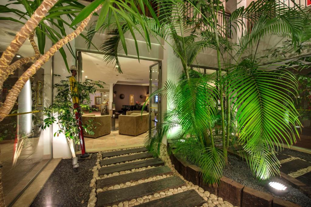 a lobby with a bunch of palm trees and stairs at Vale d'El Rei Hotel & Villas in Carvoeiro