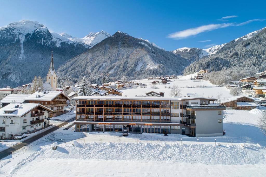 a resort in the snow with mountains in the background at Hotel Krimml in Krimml