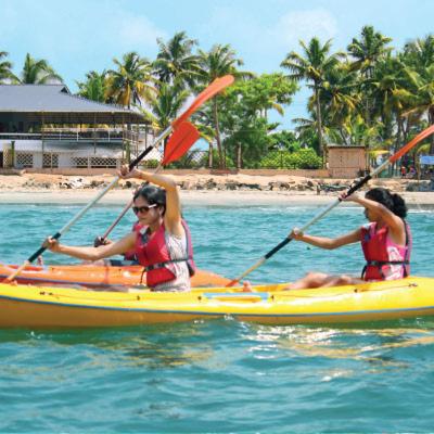 three people are in a kayak in the water at Cherai Ocean View Home in Cherai Beach