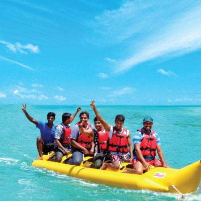 a group of men in life jackets on a raft in the ocean at Cherai Ocean View Home in Cherai Beach
