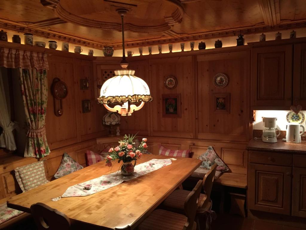 a dining room with a wooden table and a chandelier at Appartement Schuricht in Reit im Winkl