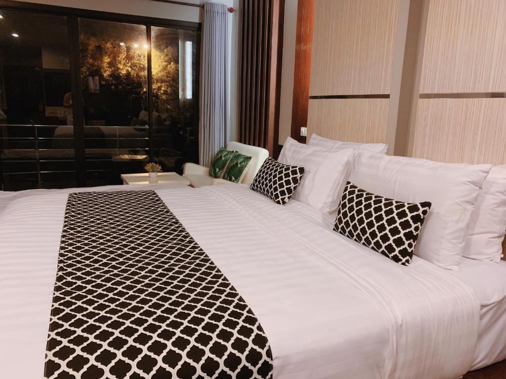 uma grande cama branca com almofadas pretas e brancas em Phi Phi Ton Sai Place em Phi Phi Don