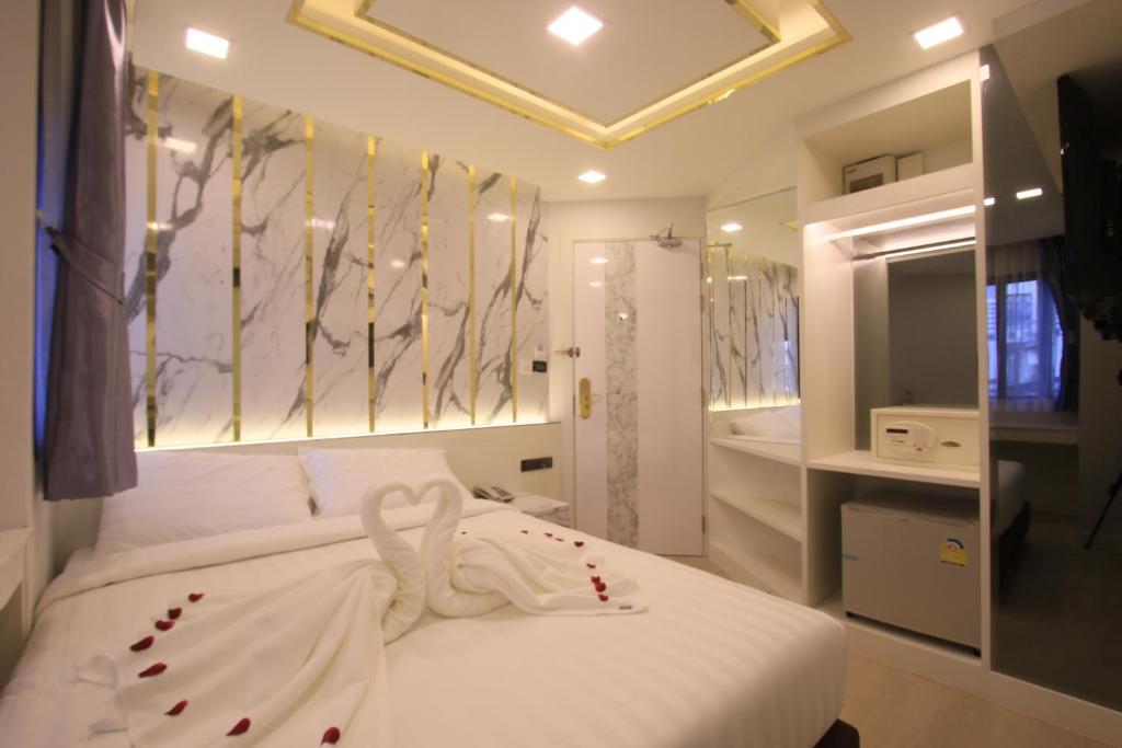 a bedroom with a bed with a swan decoration on it at Pratunam Atrium Hotel in Bangkok