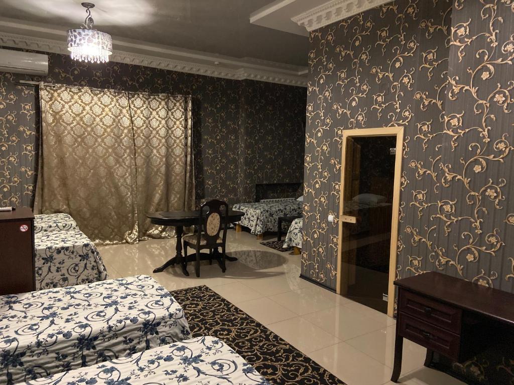 a room with two beds and a table in it at Frant-Hotel Palacе in Volgograd