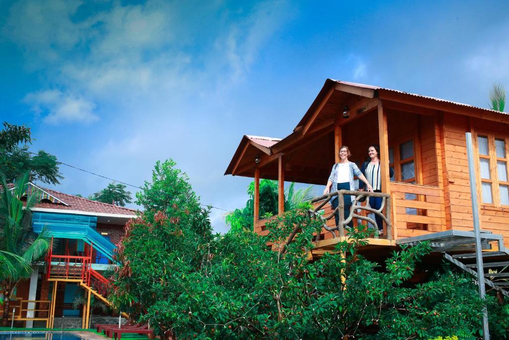 two people standing on the balcony of a house at Woodgreens Heritage Resorts in Kannur