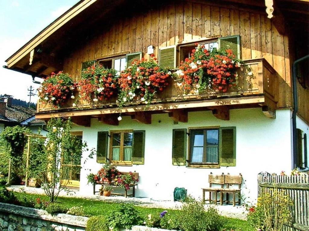 una casa con cajas de flores a un lado. en Ferienwohnungen Nutz, en Bad Wiessee