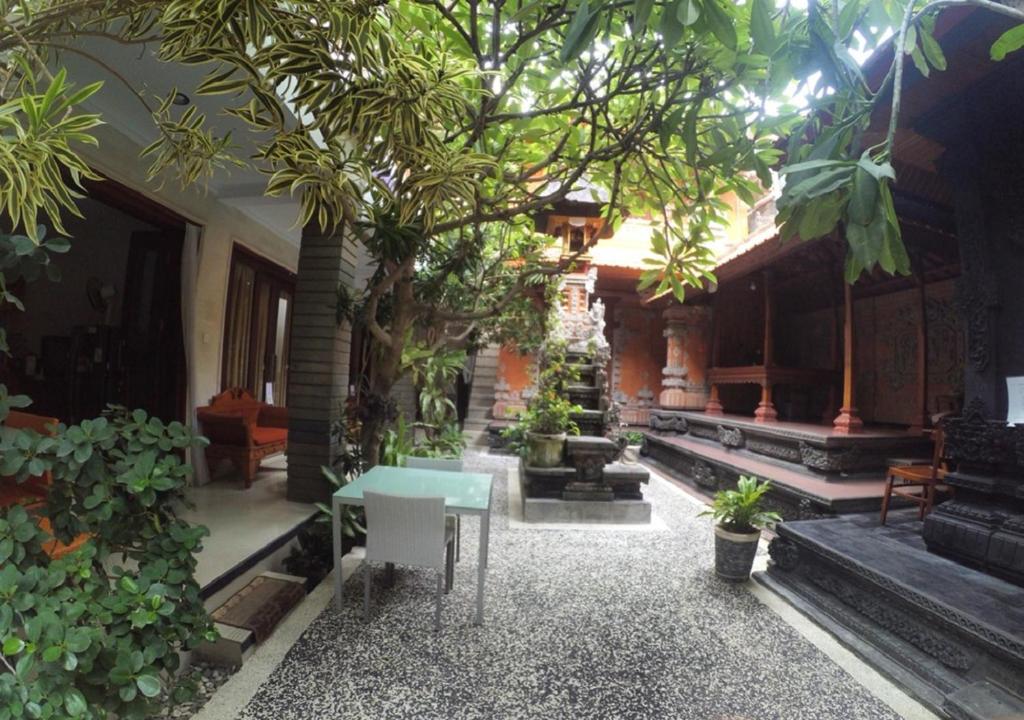 a room with a table and trees in a building at Pondok Krishna in Kuta