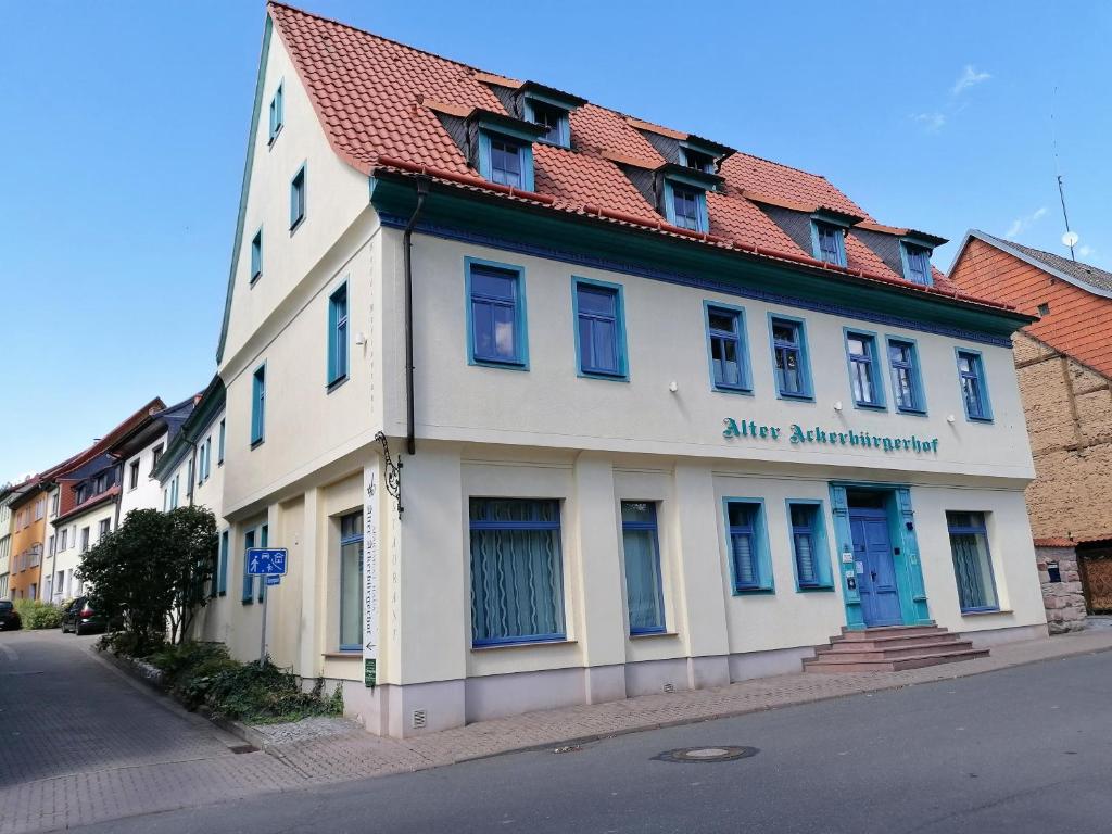 ein weißes Gebäude mit rotem Dach auf einer Straße in der Unterkunft Alter Ackerbuergerhof in Bad Frankenhausen
