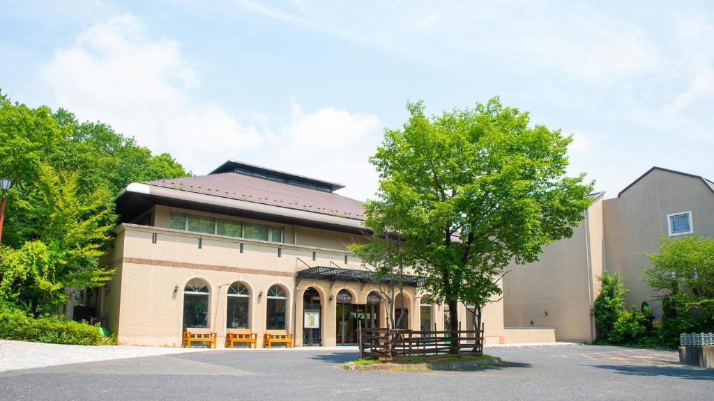 a building with a tree in front of it at Hotel Floracion Nasu in Nasu