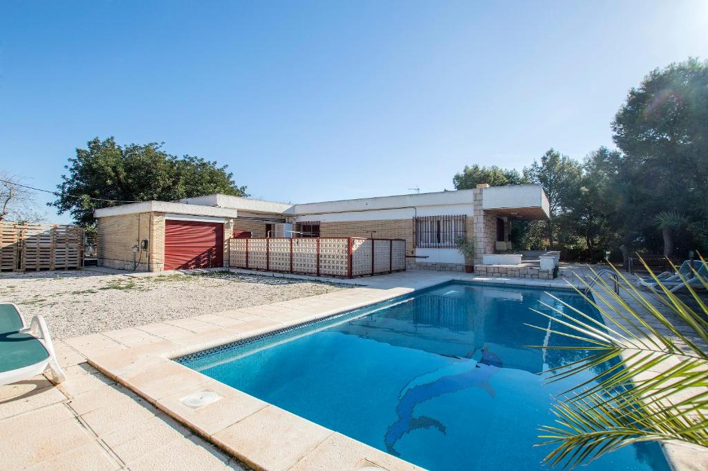 a swimming pool in front of a house at Chalet Bon Sol in El Campello