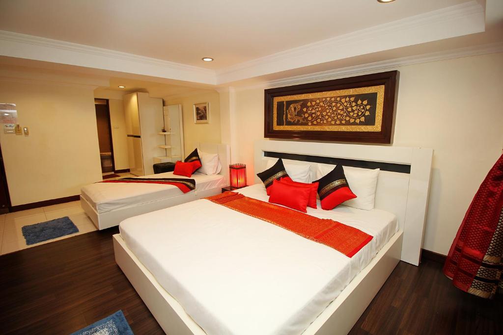 a hotel room with two beds with red pillows at Sky Silk Decoration House in Patong Beach