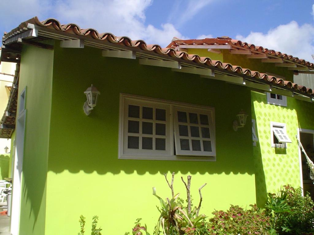 a green and white house with a window at SUÍTES Caminho do Mar in Abraão