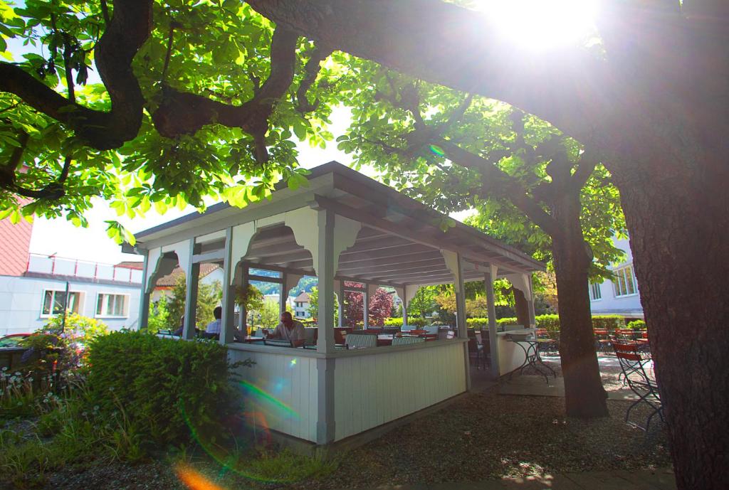 a gazebo sitting under a tree in a yard at Gasthaus zur Waldegg in Luzern
