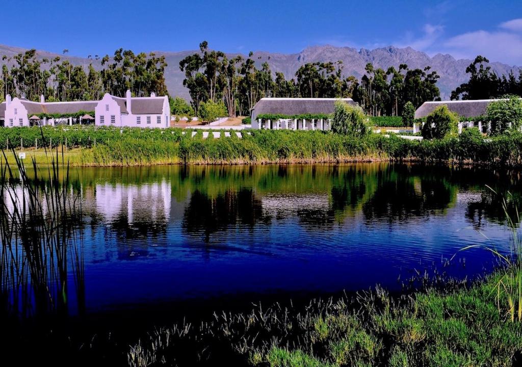 a view of a house and a lake with buildings at Rijk's Wine Estate & Hotel in Tulbagh