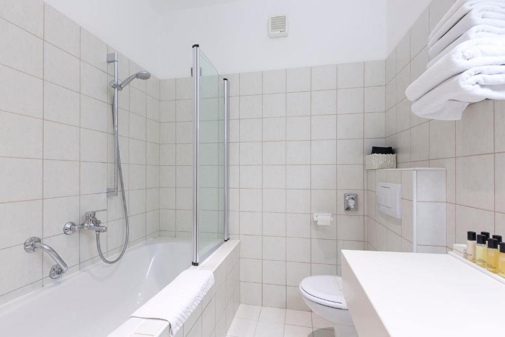 a white bathroom with a shower and a toilet at Hotel Villa Annette in Rabac
