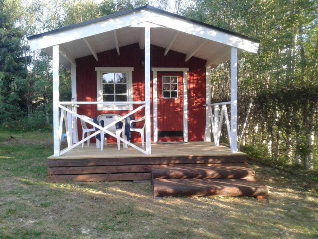 eine rote Hütte mit einer Veranda und einer Terrasse in der Unterkunft Ferienhäuschen MD Sportfiske in Sveg