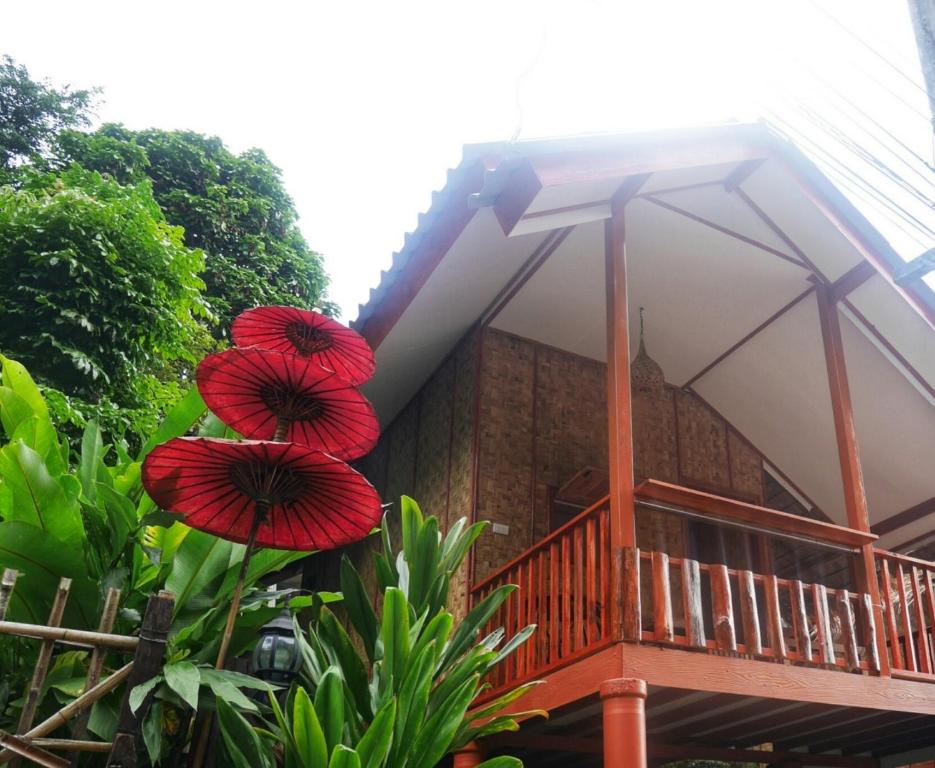 twee rode paraplu's hangen aan een huis bij Huan Kaw Fang in Mae On