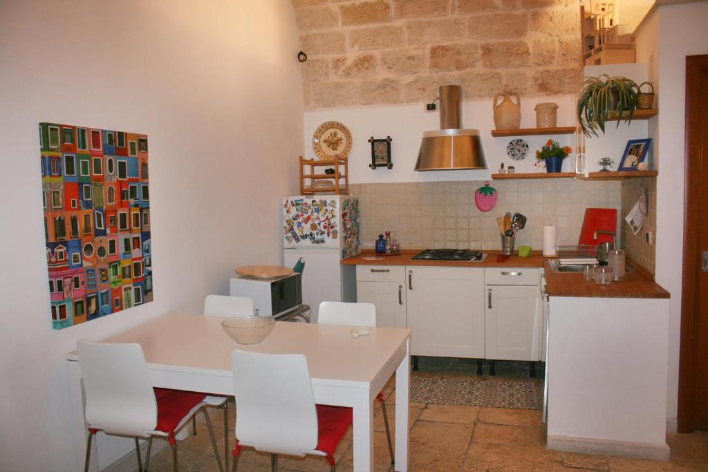 バーリにあるLa casa nel vicoloのキッチン(白いテーブル、白い椅子付)