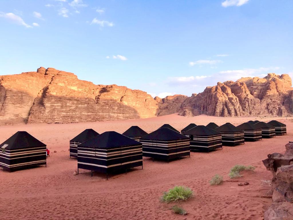 un gruppo di tende nel deserto con montagne di wadi rum Mater camp a Wadi Rum