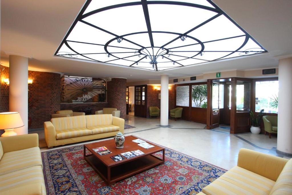 a large living room with a large chandelier at Altea Suites in Pomezia