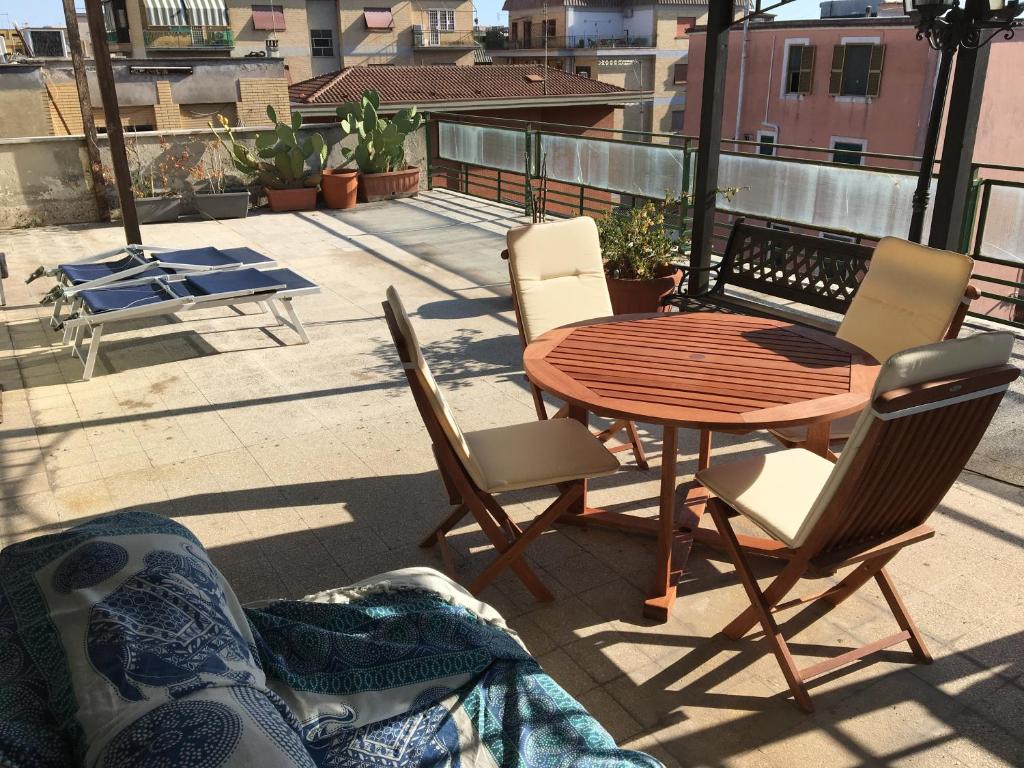 einen Holztisch und Stühle auf einer Terrasse mit einem Tisch und Stühlen in der Unterkunft Sunny Rome Attico con grande terrazzo in Rom