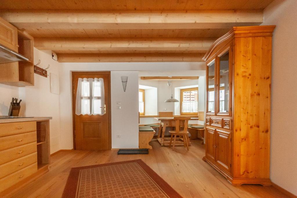 a kitchen with a wooden door and a dining room at Casa Piccolin in Falcade