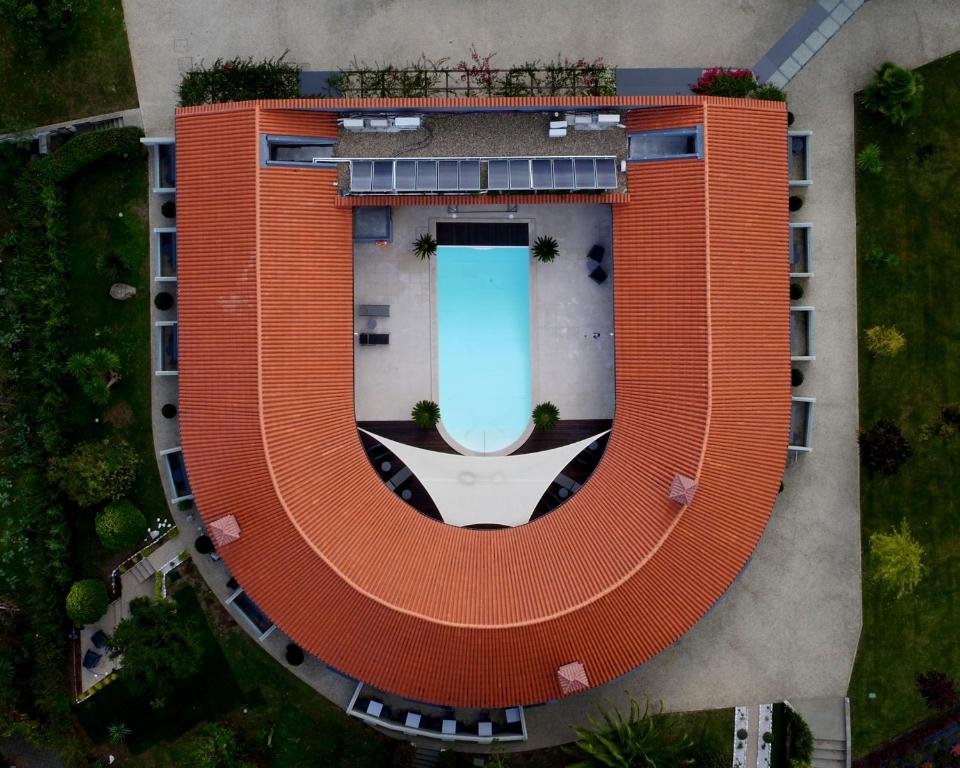 an orange building with a pool in the middle at Casa das Carpas in Vizela