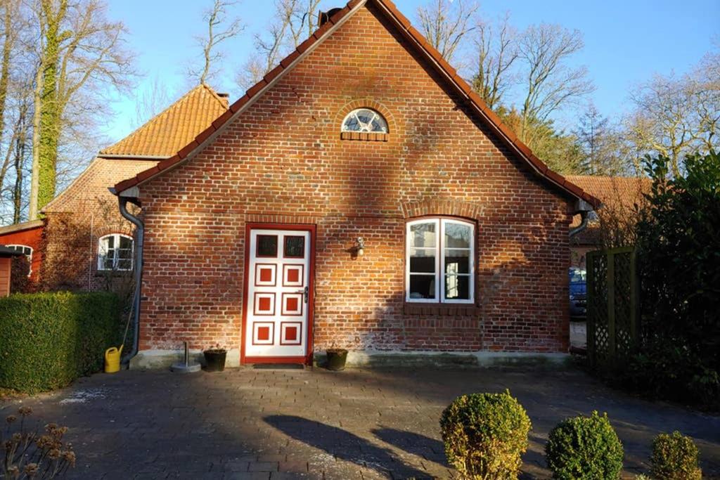 a red brick house with a white door at Gut Hohenstein - Stellmacherhaus in Barkelsby