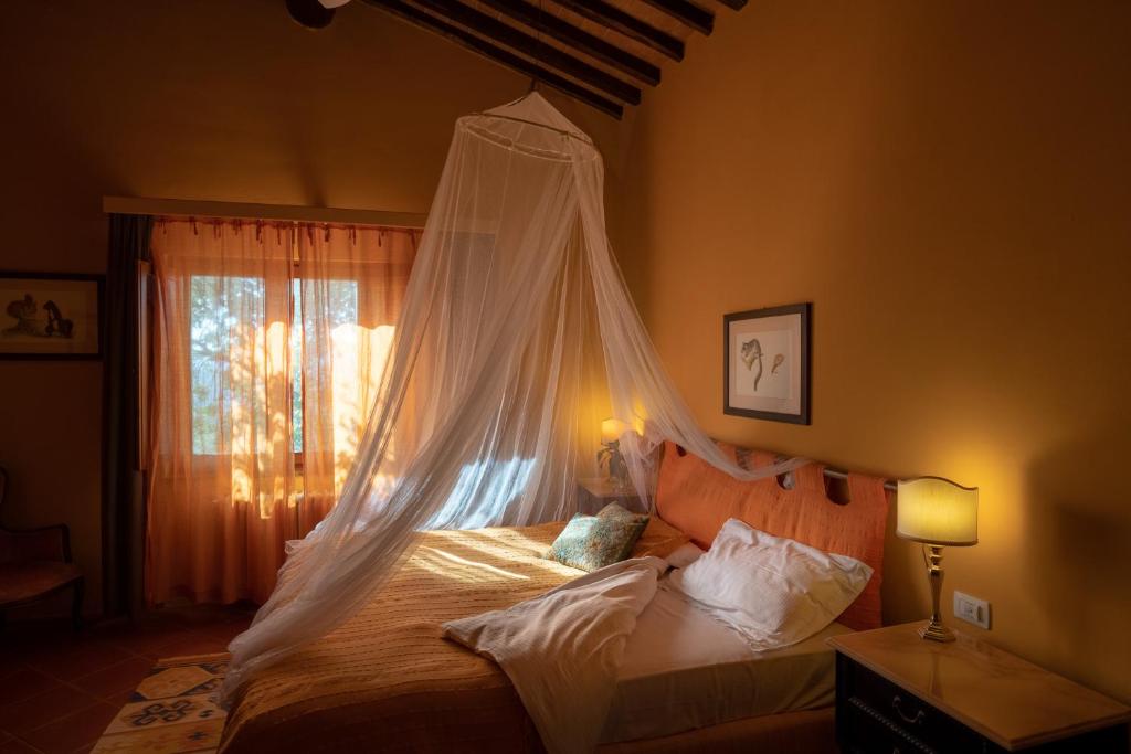 sypialnia z łóżkiem z moskitierą w obiekcie Torraccia di Chiusi Agriturismo Relais w mieście San Gimignano