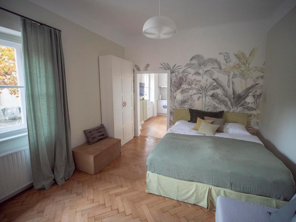 a bedroom with a large bed with a mural on the wall at Green flat by GrazRentals with garden view & parking included in Graz