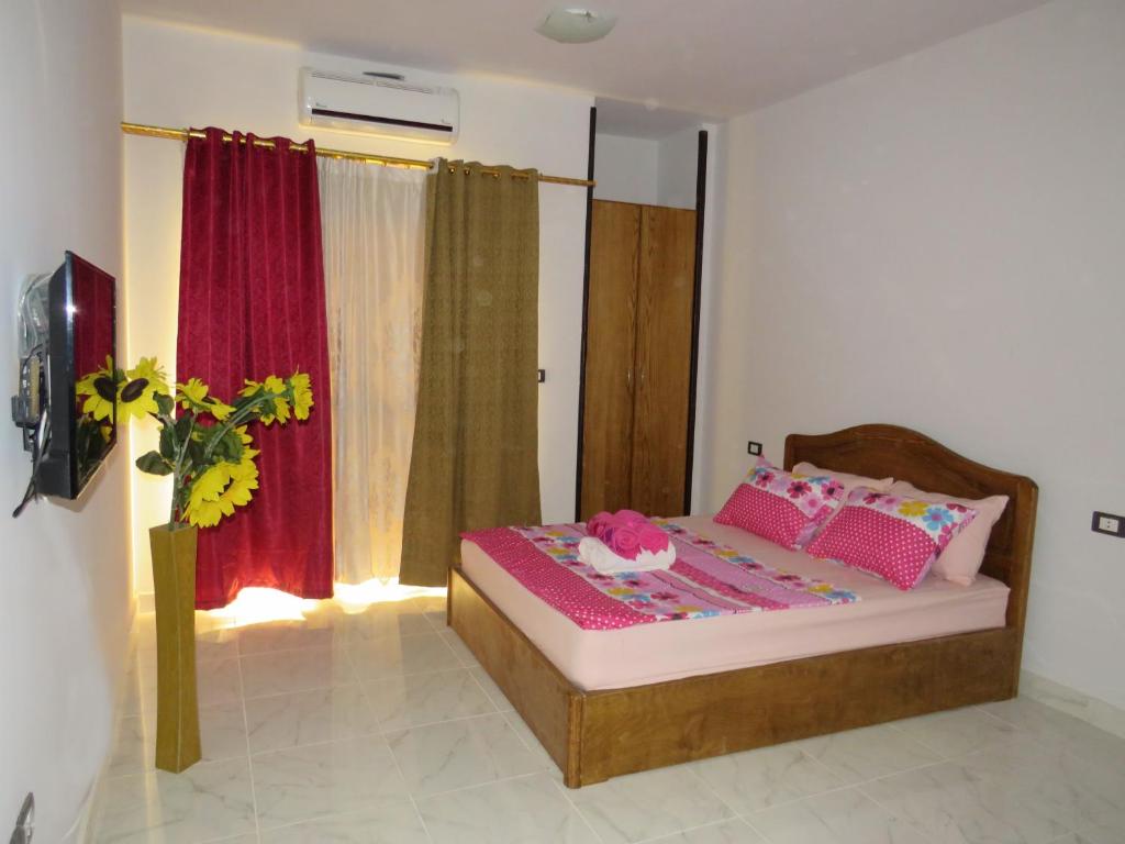 um quarto com uma cama com almofadas cor-de-rosa em Apartment Bella Rosa near the sea RedSeaLine em Hurghada
