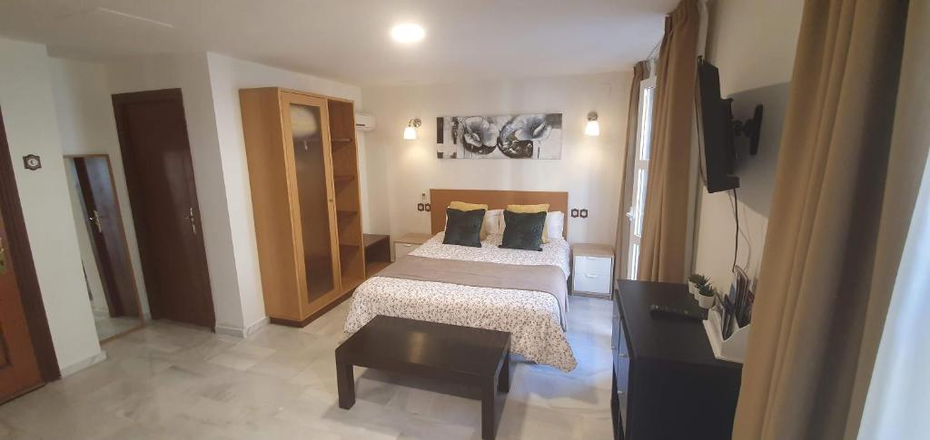 - une petite chambre avec un lit et une table dans l'établissement Fan Flat Carretería, à Malaga
