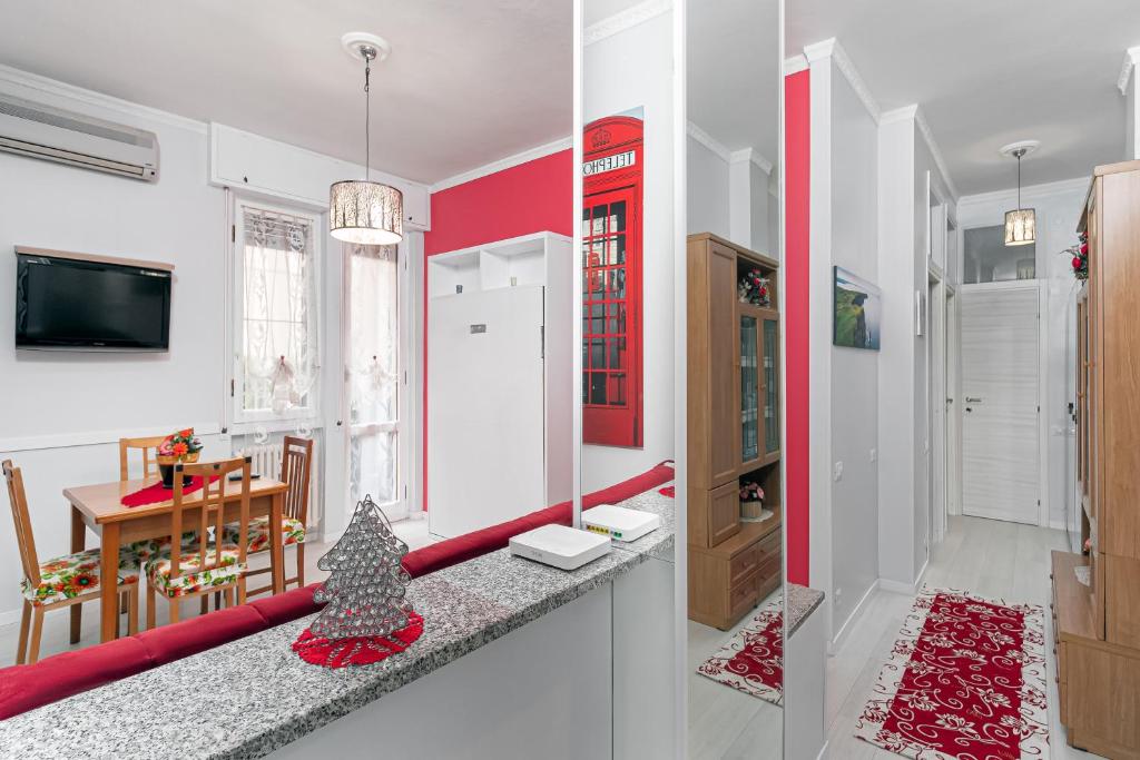 cocina y comedor con paredes rojas y blancas en Nico&Cinzia Apartments, en Milán