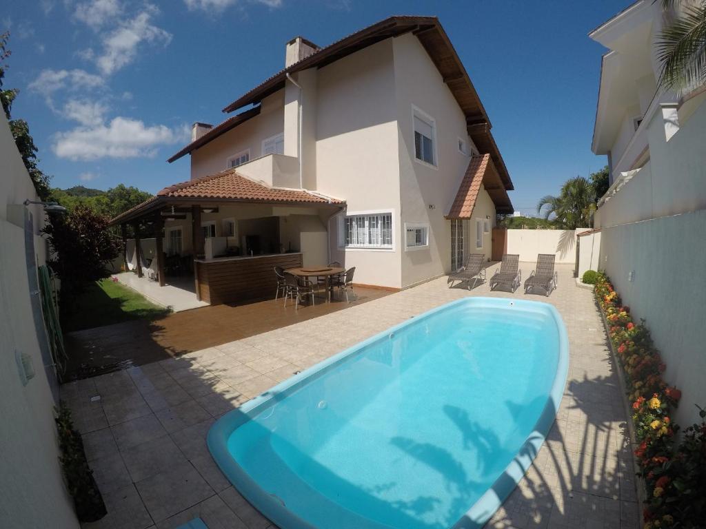 a swimming pool in front of a house at Casa Jurere Internacional Florianópolis in Florianópolis