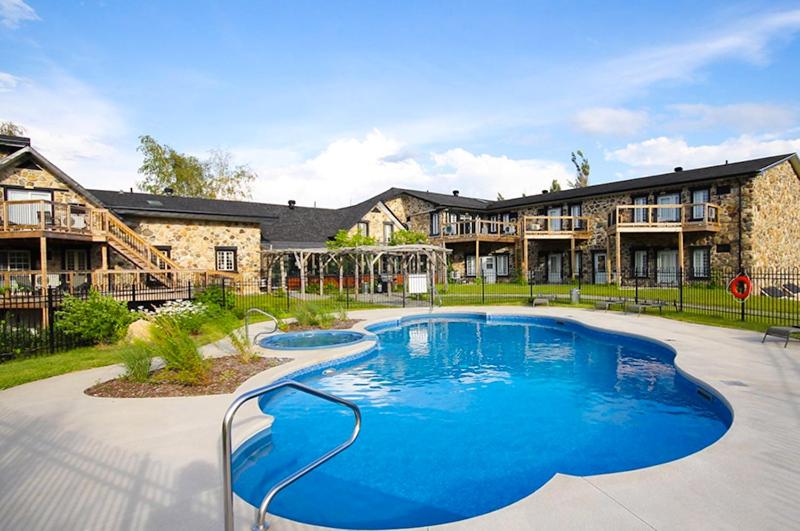 a large swimming pool in front of a building at Condos Hotel Lion D'Or in Magog-Orford