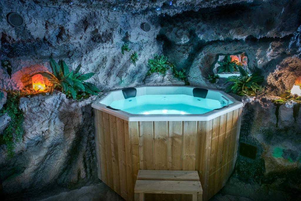 a bath tub in a cave with a stone wall at Gorgeous Villa in Cluj-Napoca