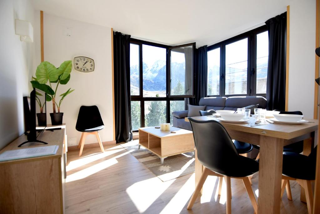 a living room with a table and chairs in a room at Lux Renard "Acceso directo a pistas" in Pas de la Casa
