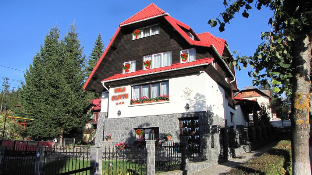 a house with a red roof at Villa Elitte Predeal in Predeal