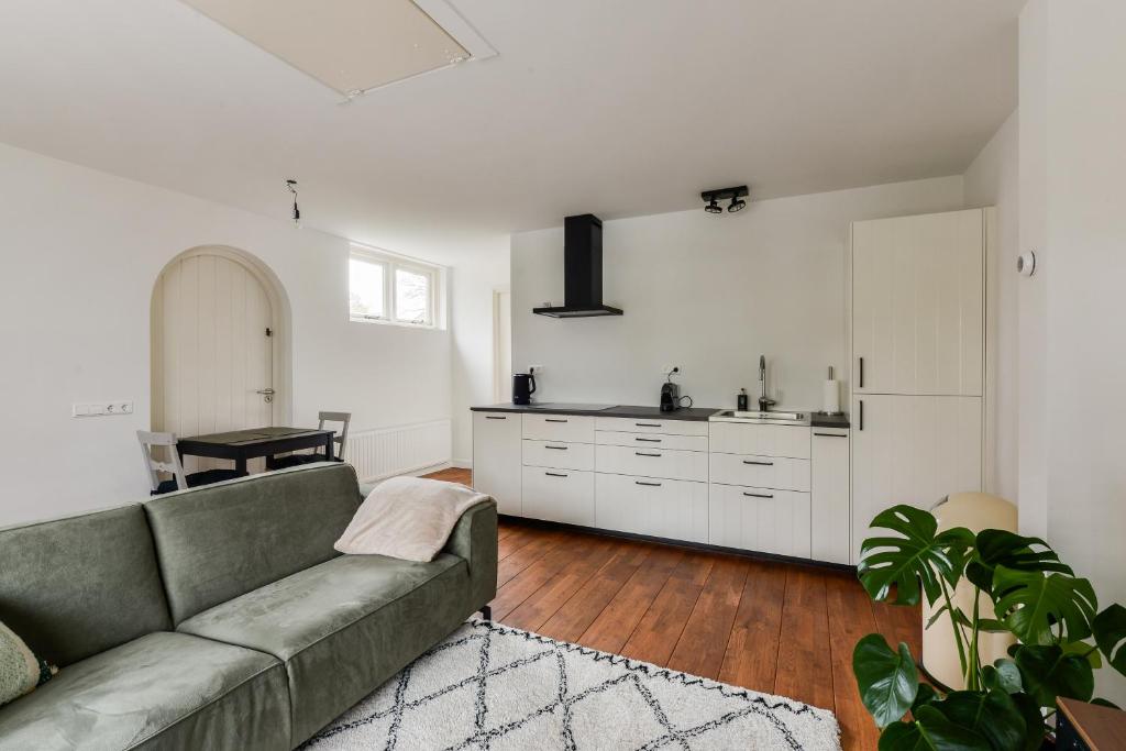 sala de estar con sofá y cocina en Luxury Garden View Apartment, en Zandvoort