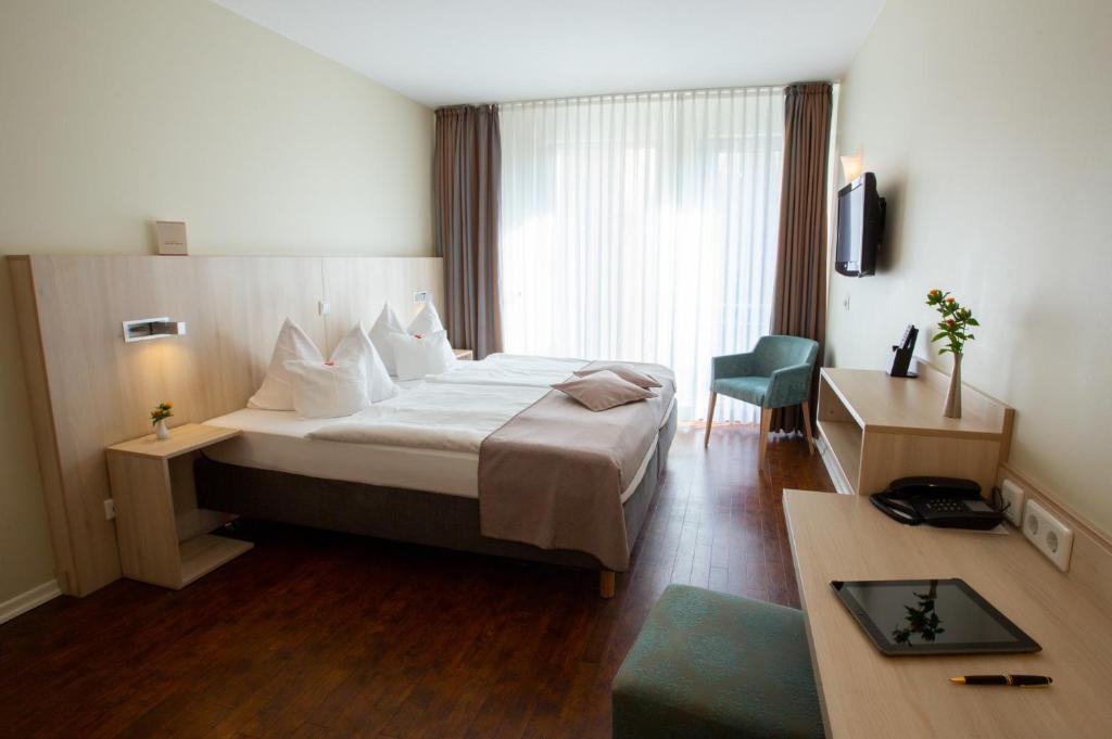 Stadthaushotel Hamburg - Inklusionshotel في هامبورغ: غرفة في الفندق مع سرير ومكتب