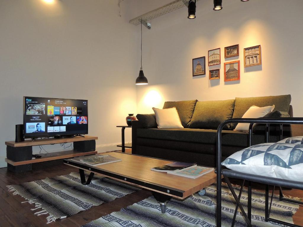 a living room with a couch and a tv at Stylish duplex in Caseros Boulevard - San Telmo in Buenos Aires